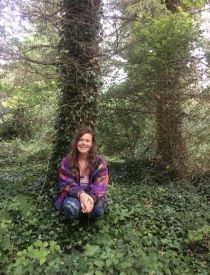 Deborah's grown-up daughter sitting by the tree under which she was born