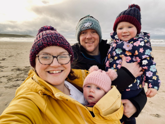 colour photo of jane furness, and her family, on a beach