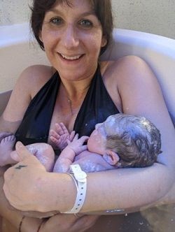 Image of Lois Hubbard cradling her newborn baby in the birthing pool