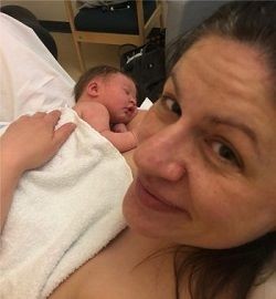 Image of Clare Hardy cradling her newborn