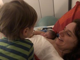 Hannah Lyons nursing newborn with toddler looking on