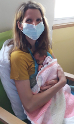 Liz Thomas, masked, in hospital with newborn