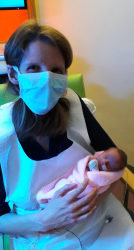 Liz Thomas, masked, in hospital with newborn